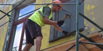 Рабочий восстанавливает дом в ДНР