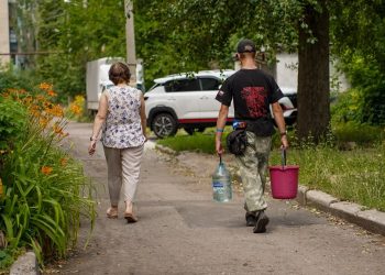 Волонтёр помогает донести воду, ДНР